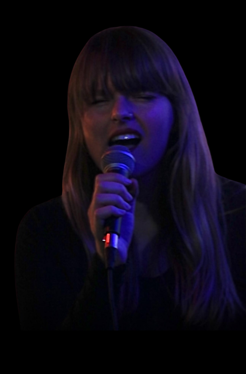 Annabelle Hift performing and singing into a mike with a black background